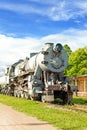 Old rustic steam locomotive on station platform. Cloudy sky back Royalty Free Stock Photo