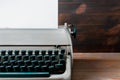 Old and rustic typewriter with blank white paper for own text.