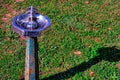 Old, rustic, water fountain with a grassy background