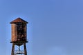 Old, rustic water tower with blue sky background