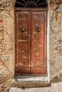 An old, rustic and weathered wooden door with cracked paint and rusty door knockers Royalty Free Stock Photo