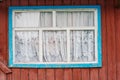 Old rustic window in blue and white on a brown wall Royalty Free Stock Photo
