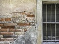 old rustic wood frame with metal bar and glass louver in cracking brick wall close-up Royalty Free Stock Photo