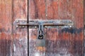 Old and rustic wooden door with a rusty latch Royalty Free Stock Photo