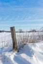 An old rustic wooden fence post in the snow Royalty Free Stock Photo