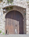 Old rustic wooden gate on stone wall Royalty Free Stock Photo