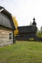 An old rustic wooden hut. In the background there is a rustic wooden church. Royalty Free Stock Photo