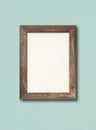 Old rustic wooden picture frame hanging on a light blue wall Royalty Free Stock Photo