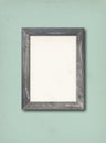 Old rustic wooden picture frame hanging on a light blue wall Royalty Free Stock Photo