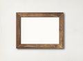 Old rustic wooden picture frame hanging on a white wall Royalty Free Stock Photo