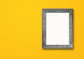 Old rustic wooden picture frame hanging on a yellow wall. Horizontal banner Royalty Free Stock Photo