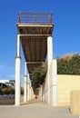 Old rusting abandoned pier with metal railings and concrete columns in paphos cyprus with a sunlit blue sky