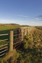 An old rusting metal Kissing Gate set into a Drystone wall to allow People to access the footpath to Benholm Royalty Free Stock Photo