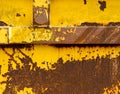 Old rusting metal skip container with yellow pealing paint