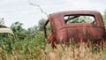 Old rusting vintage car or barn find in an overgrown field Royalty Free Stock Photo