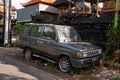 An old, rusty, abandoned car is standing in the grass on the side of the road Royalty Free Stock Photo