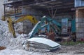 Old rusty abandoned construction excavators with a bucket on the ground in a hangar at a construction site