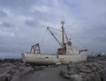 Old rusty abandoned fishing boat, ship wreck standing on rock, s Royalty Free Stock Photo