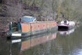 Old rusty abandoned narrowboat or converted canal barge moored