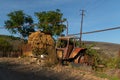 Old rusty and abandoned tractor on the street with some fodder in the background in the town of Azokh part of the Janapar Trail in Royalty Free Stock Photo