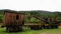 Old, rusty and abandoned waggon placed at a grass field with hills behind it Royalty Free Stock Photo