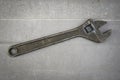 Old rusty adjustable wrench on a metal background. Old style. Royalty Free Stock Photo