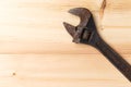 Old, rusty adjustable wrench on wooden background. Top view. Flat lay. Copy space Royalty Free Stock Photo