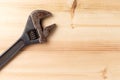 Old, rusty adjustable wrench on wooden background. Top view. Flat lay Royalty Free Stock Photo