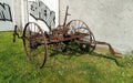 Old rusty agricultural equipment standing by a barn`s wall on a green lawn, Bad Homburg, Germany Royalty Free Stock Photo