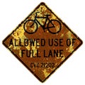 Old rusty American road sign - Bicycle May Use Full Lane on the roadway, San Francisco Royalty Free Stock Photo