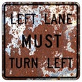 Old rusty American road sign - Left lane MUST turn left Royalty Free Stock Photo