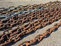 An old rusty anchor chain is laid out on the berth for disposal Royalty Free Stock Photo