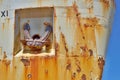 Old rusty anchor on the side of and old metal shipwreck in the dock Royalty Free Stock Photo