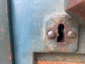 Old rusty ancient iron metal keyhole for opening with a key on a door painted with blue paint Royalty Free Stock Photo