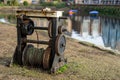 An old rusty Barge winch next to a canal used as part of an old canal lock