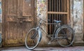 Old rusty bicycle at the doorway of a weathered house