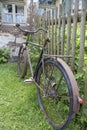 Old rusty bicycle leaning against a wooden fence Royalty Free Stock Photo