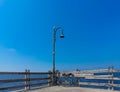 Old Rusty Bicycle Park Under The Damage Lamppost At The Wooden Pier of Marina Beside The Sea Royalty Free Stock Photo