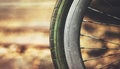 Old rusty bicycle wheel against warm blur background