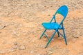 Old rusty blue chair leave alone in abandoned dried backyard. Royalty Free Stock Photo