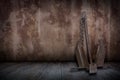 Old rusty boat anchor in plaster walls and old wooden floors.