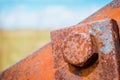 Old rusty bolts and steel nuts in the background a blurred sky and a field. Royalty Free Stock Photo