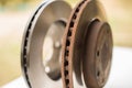 Old rusty brake disc and new disc in the background. Royalty Free Stock Photo