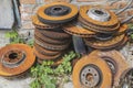 Old rusty brake discs spring and canister lie in the grass near a brick wall Royalty Free Stock Photo