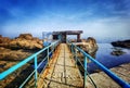 Old rusty bridge leading to the sea water and rocks. Seaside landscape wallpaper