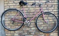 Old rusty broken bike hanging on a yellow brick wall Royalty Free Stock Photo