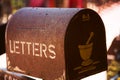 Old rusty brown mailbox with letterbox text, in worn condition, outdoor Royalty Free Stock Photo