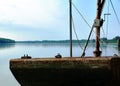 Old rusty brown steel pontoon barge on quiet blue river with panorama