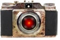 Old rusty camera with a red lens eye Royalty Free Stock Photo