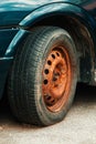 Old rusty car wheel rim and worn tire Royalty Free Stock Photo